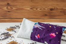 Load image into Gallery viewer, Purple fabric with unicorn design on a white surface surrounded with lavender and flax seed