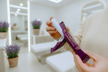 Load image into Gallery viewer, Person holding a lavender refreshment towel with a blurred outdoor background